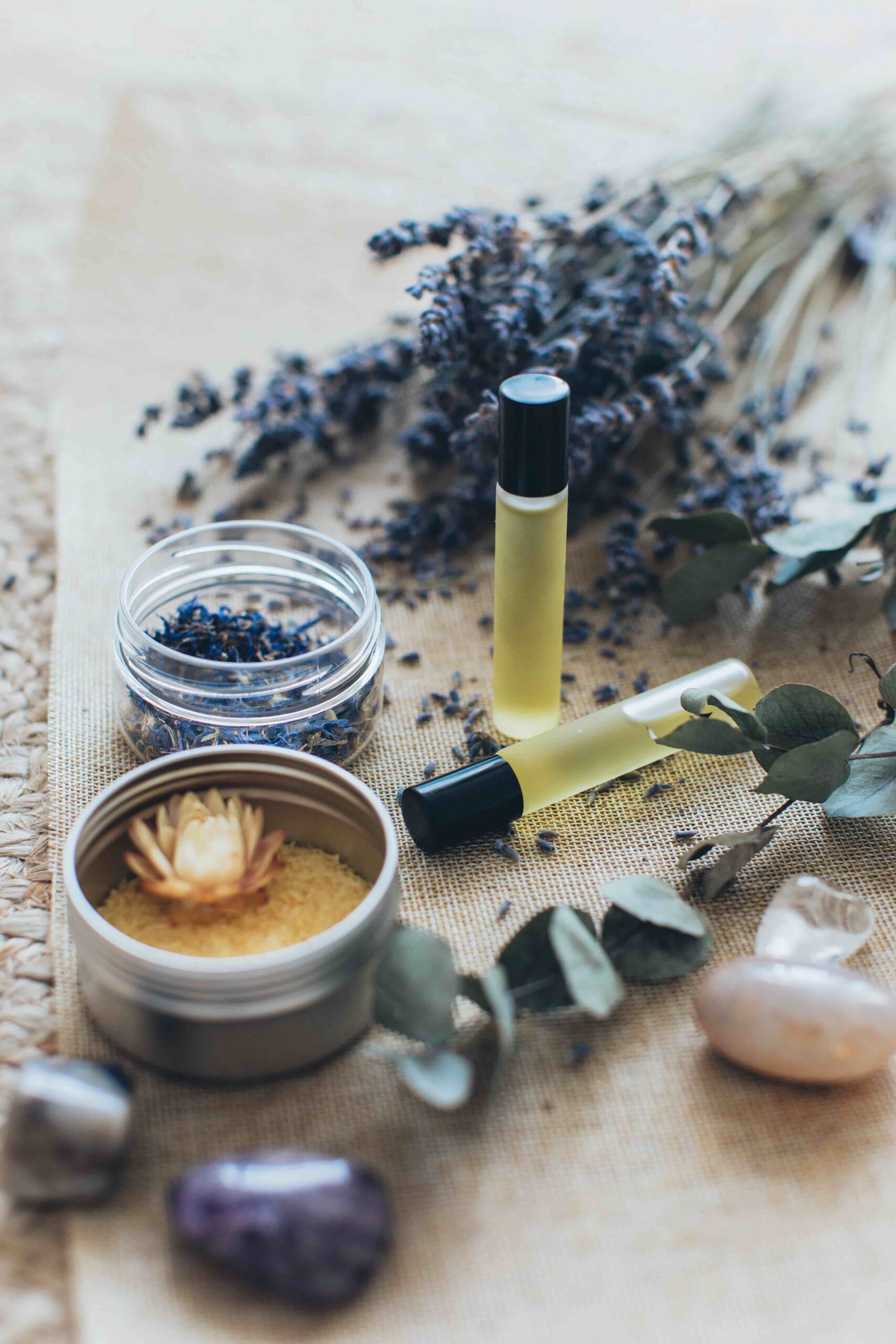 essential oil roller balls next to tins and lavender