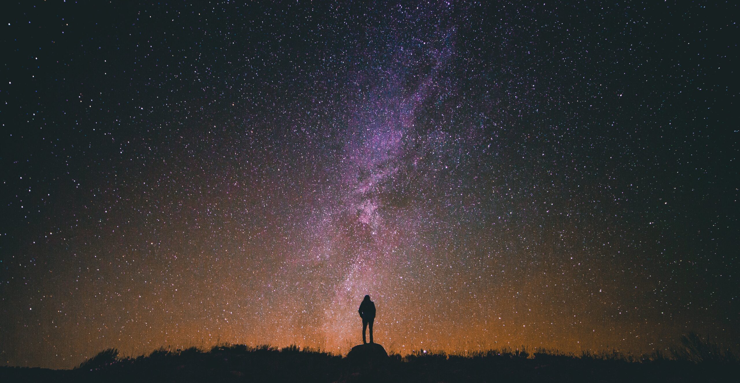 person standing under a starry night sky