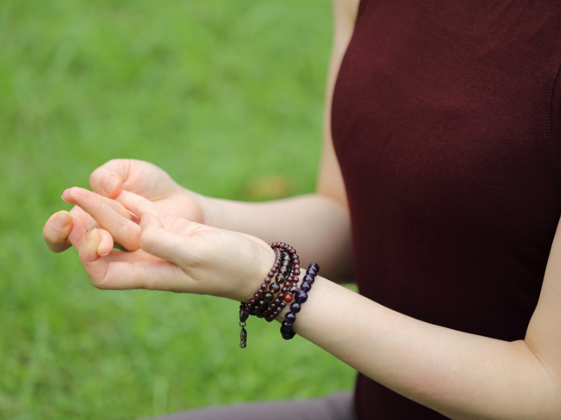 Close up of a woman performing a hand mudra, illustrating the practice of directing prana through intentional gestures.