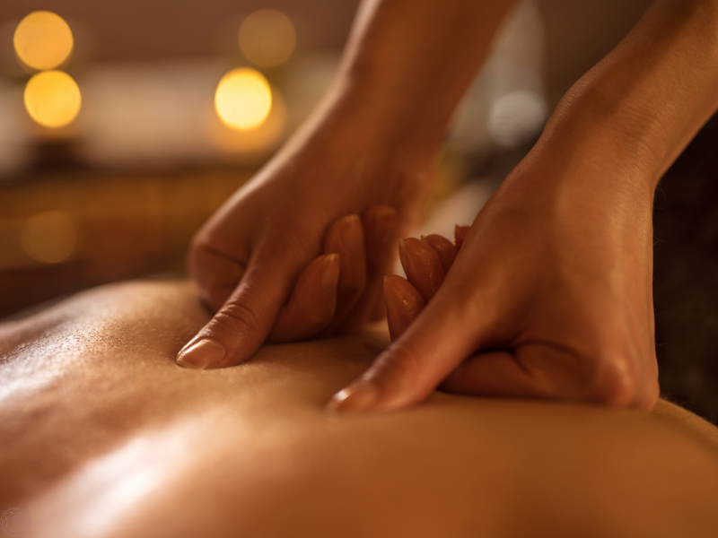 Close-up of hands giving a back massage, symbolizing stimulation and balance of the nadis through bodywork and energy flow.