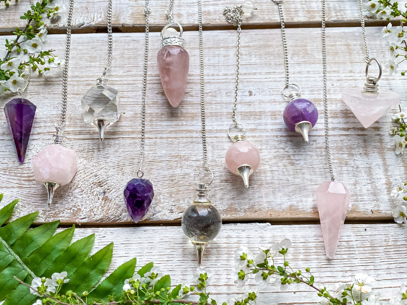 Collection of colorful crystal pendulums representing the many expressions of duality and energetic balance.
